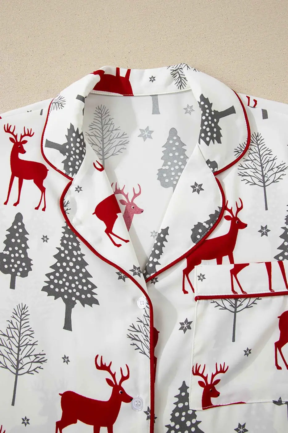Full top view of White Christmas Print Velvet Trim Pyjamas with button front and red velvet piping, showcasing cheerful holiday print.