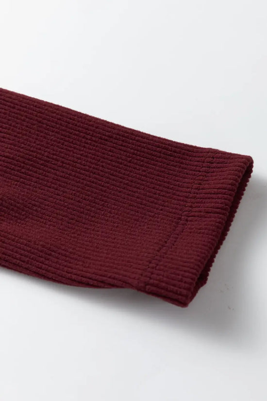 Close-up of sleeve on brown ribbed long sleeve crop top highlighting fine ribbed texture and stretch fabric for comfort.