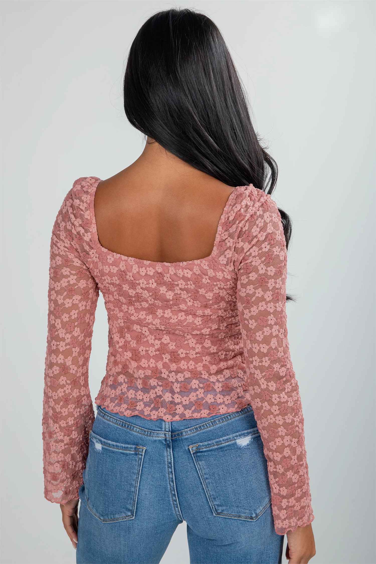 Back view of pink floral lace blouse featuring square neckline and fitted silhouette. Elegant choice for weddings and night-out occasions.