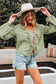 Model wearing Meadow Cotton Blouse - Soft & Lightweight | FashionFitz with wide sleeves and bow cuffs, styled with a hat and denim shorts.