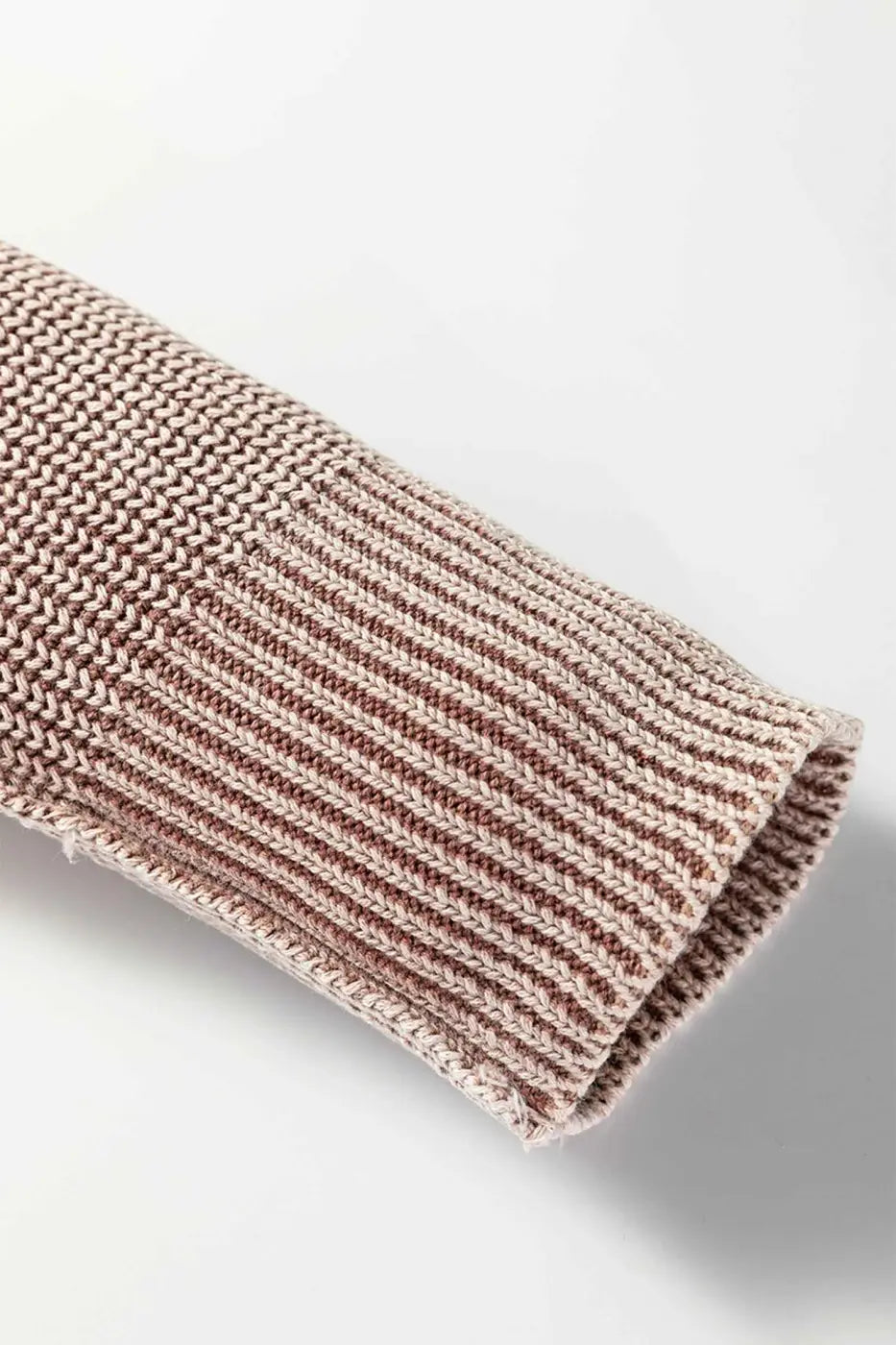 Close-up of sleeve cuff on brown stonewash patchwork knit open cardigan, highlighting ribbed knit and finished edge.