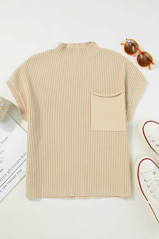 Flat lay of oatmeal ribbed knit sweater dress with short sleeves and chest pocket, styled with sunglasses and sneakers.