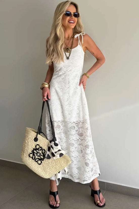 Long White Lace Overlay Maxi Dress with sleeveless design and feminine lace texture, paired with accessories for a chic summer look.