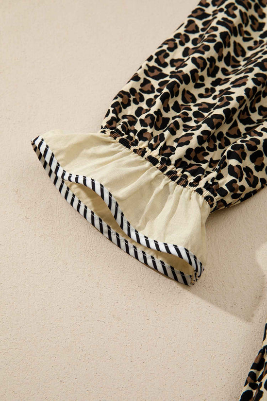 Detailed view of sleeve cuff on Leopard Print Striped Trim Mini Dress with ruffled hem and striped trim for stylish summer fashion.