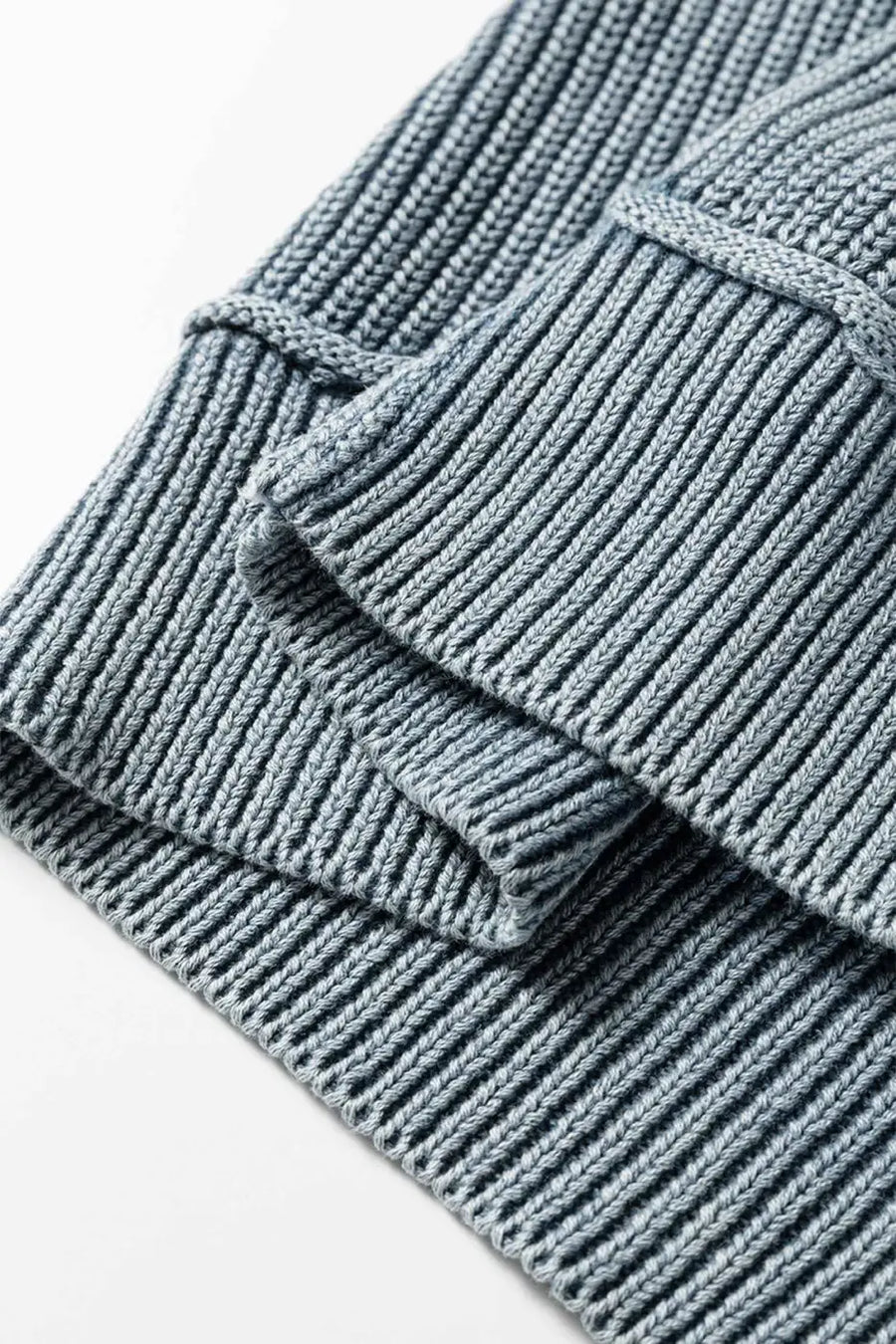 Folded sleeve and seam detail of blue Women's Stonewash Patchwork Knit Open Cardigan, showing ribbed knit pattern.