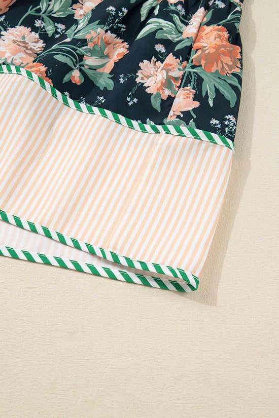 Hem detail of Ladies Blue Floral Shift Mini Dress with peach striped panel and green piping, adding contrast to the floral spring design.