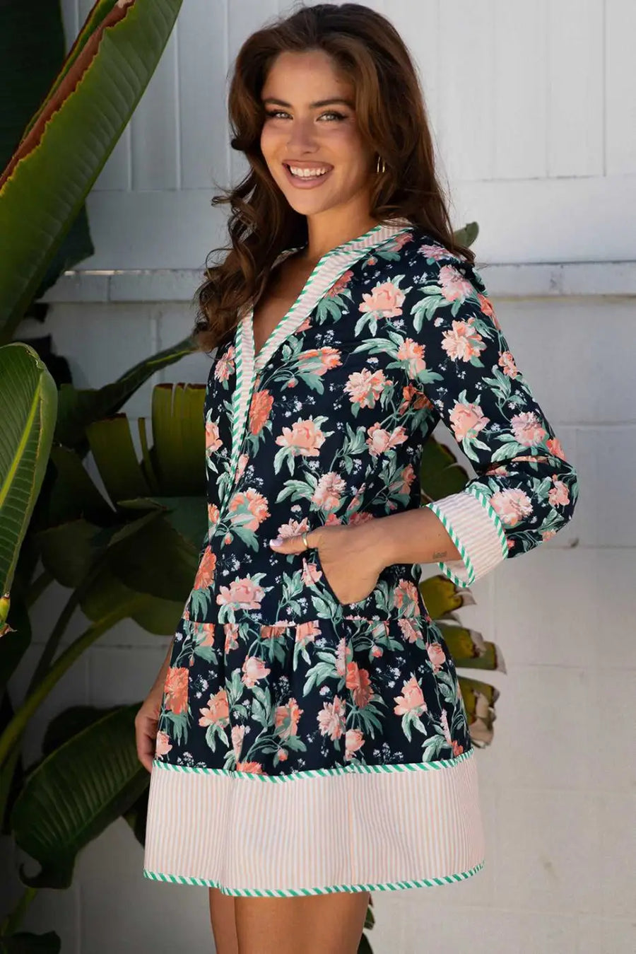 Side profile of the Ladies Blue Floral Shift Mini Dress with pockets, striped trim, and vibrant floral print, perfect for daily spring occasions.