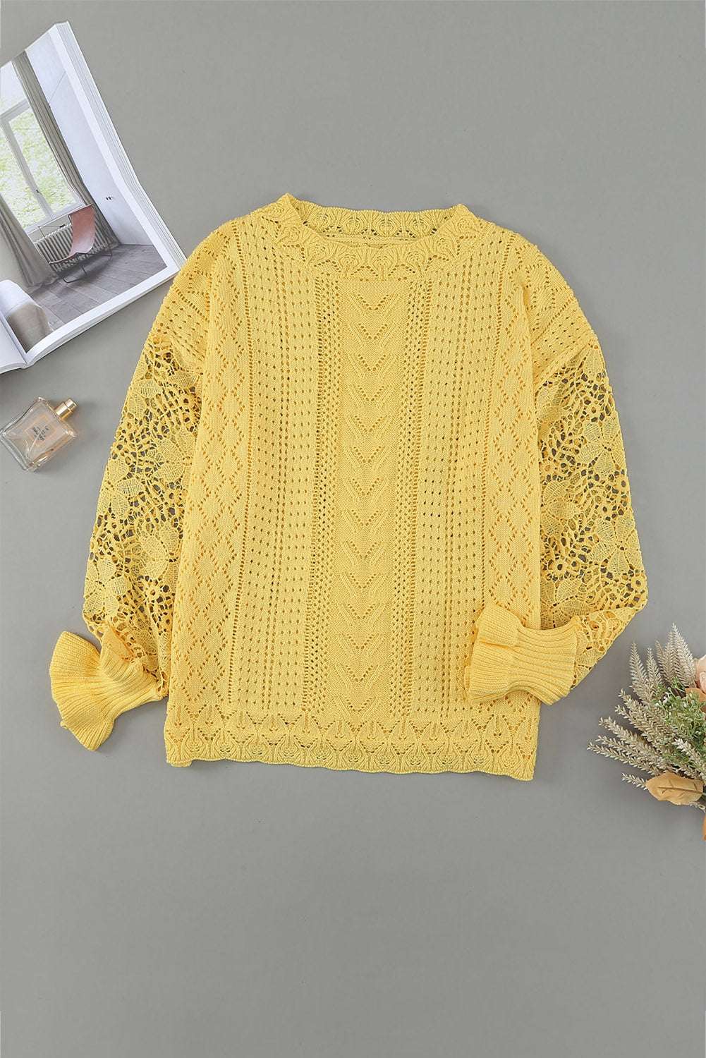 Flat lay of Yellow Crochet Lace Pointelle Knit Sweater on gray background, displaying full front design and intricate lace sleeve details.