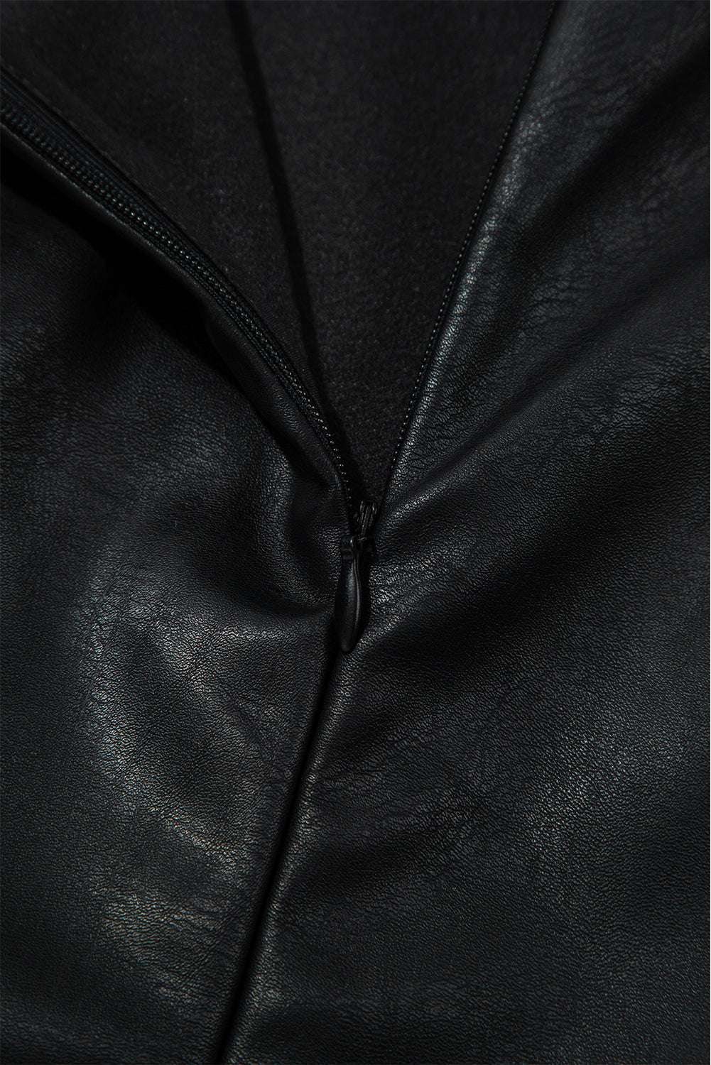 Zipper close-up on Black Vegan Leather Sleeveless Mini Dress, showcasing durable hardware and sleek finish for daily wear.