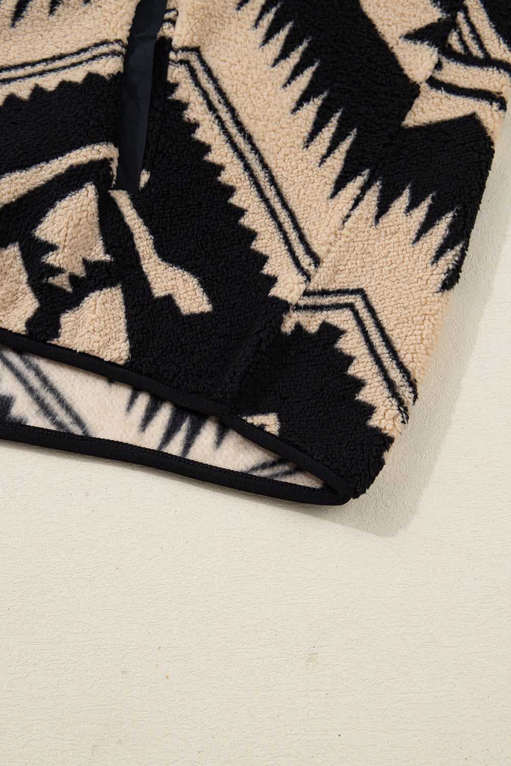 Hem detail of Women's Black Plus Size Aztec Print Plush Sweatshirt, featuring clean stitching and thick sherpa fleece for winter comfort.