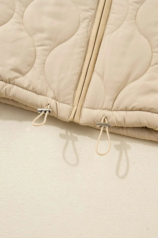 Bottom hem of Quilted Fleece‑Lined Winter Gilet in khaki showing adjustable drawstrings and double zipper design.