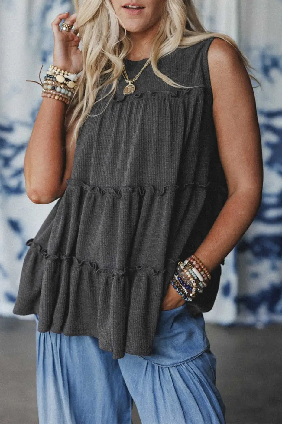 Dark grey tiered frill tank top for women styled with light blue pants, featuring a relaxed A-line fit and textured fabric.