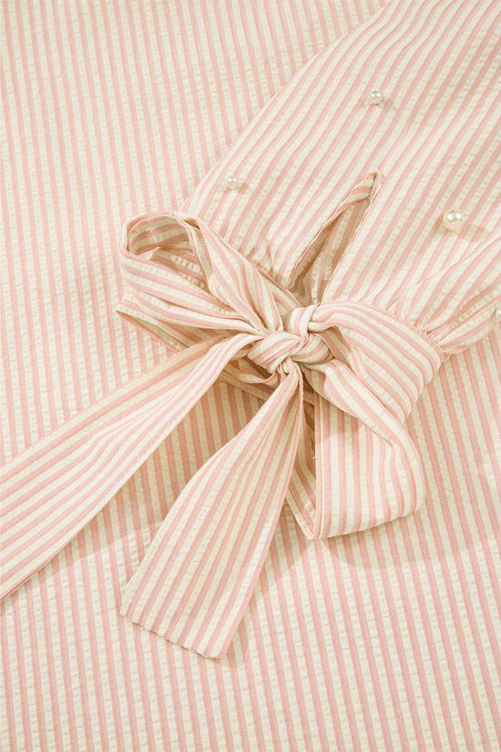 Detail of the bow cuff on the Bow Cuff Pearl Embellished Blouse, highlighting feminine striped fabric and tied sleeve design.