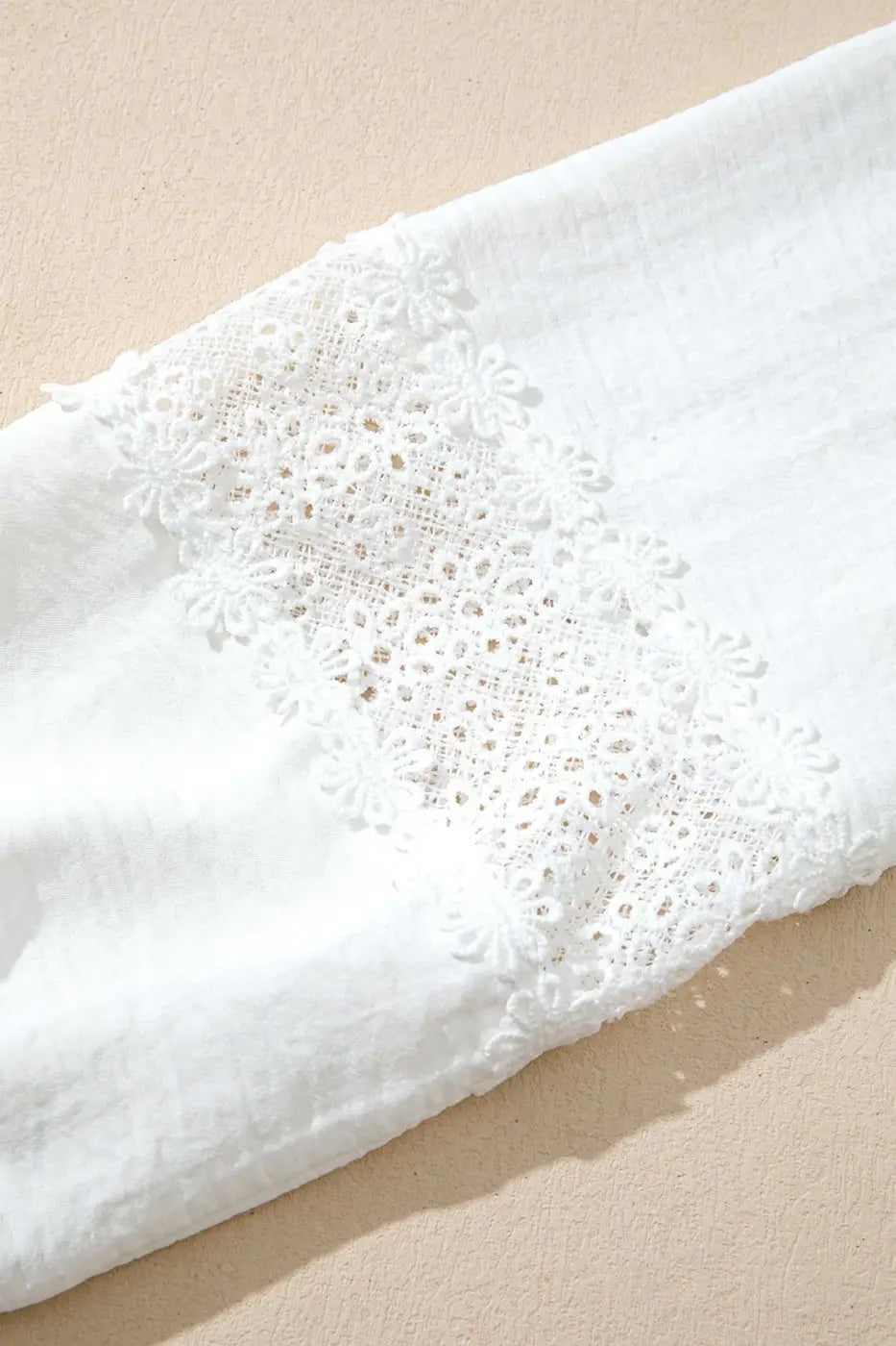 Detailed view of the floral guipure lace panel on the sleeve of the White Guipure Lace Frill Blouse, showcasing its intricate craftsmanship.
