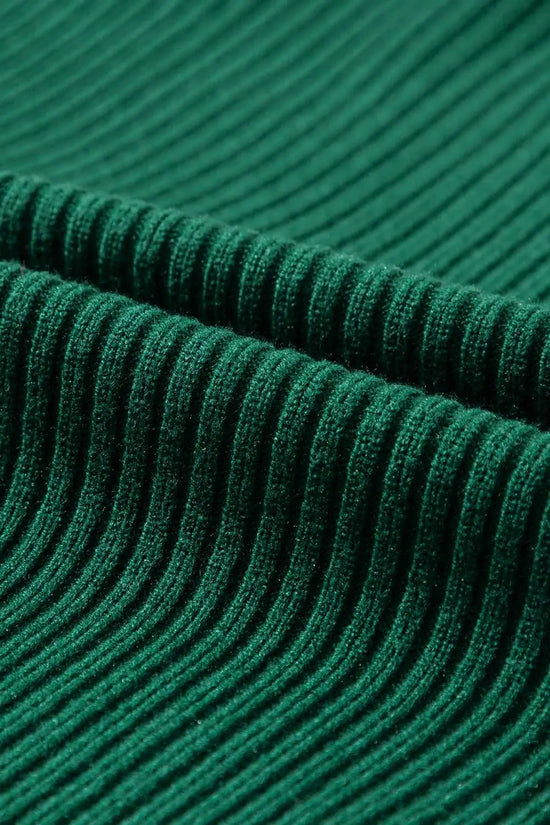 Detailed view of green ribbed knit fabric texture from the short sleeve sweater, highlighting its soft and cozy material.