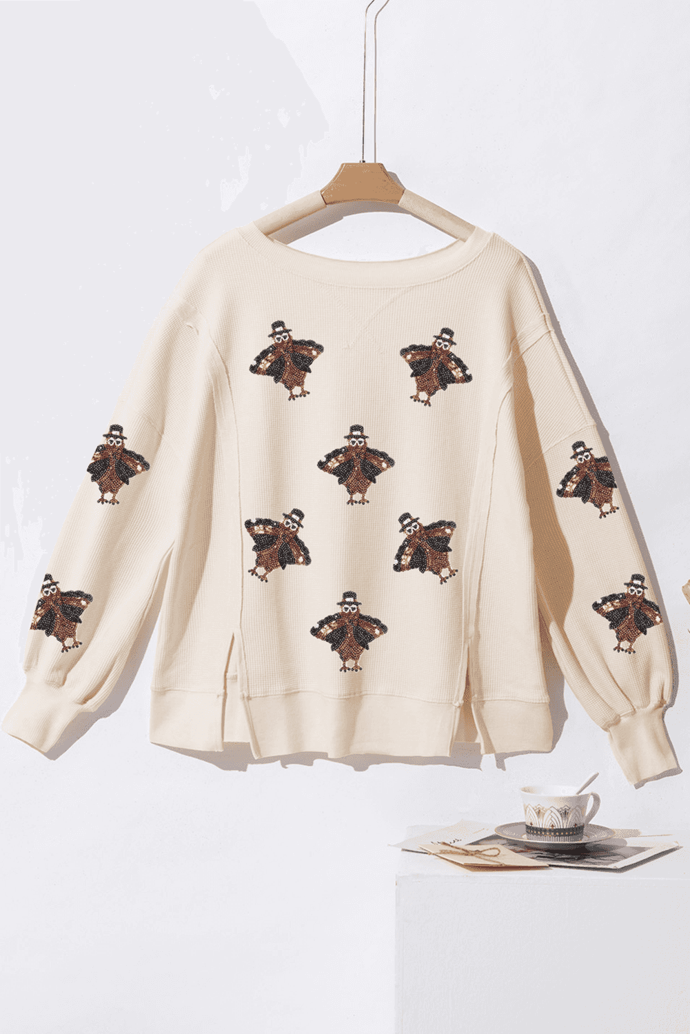Thanksgiving Oversized Knit Top on a hanger against a white background.