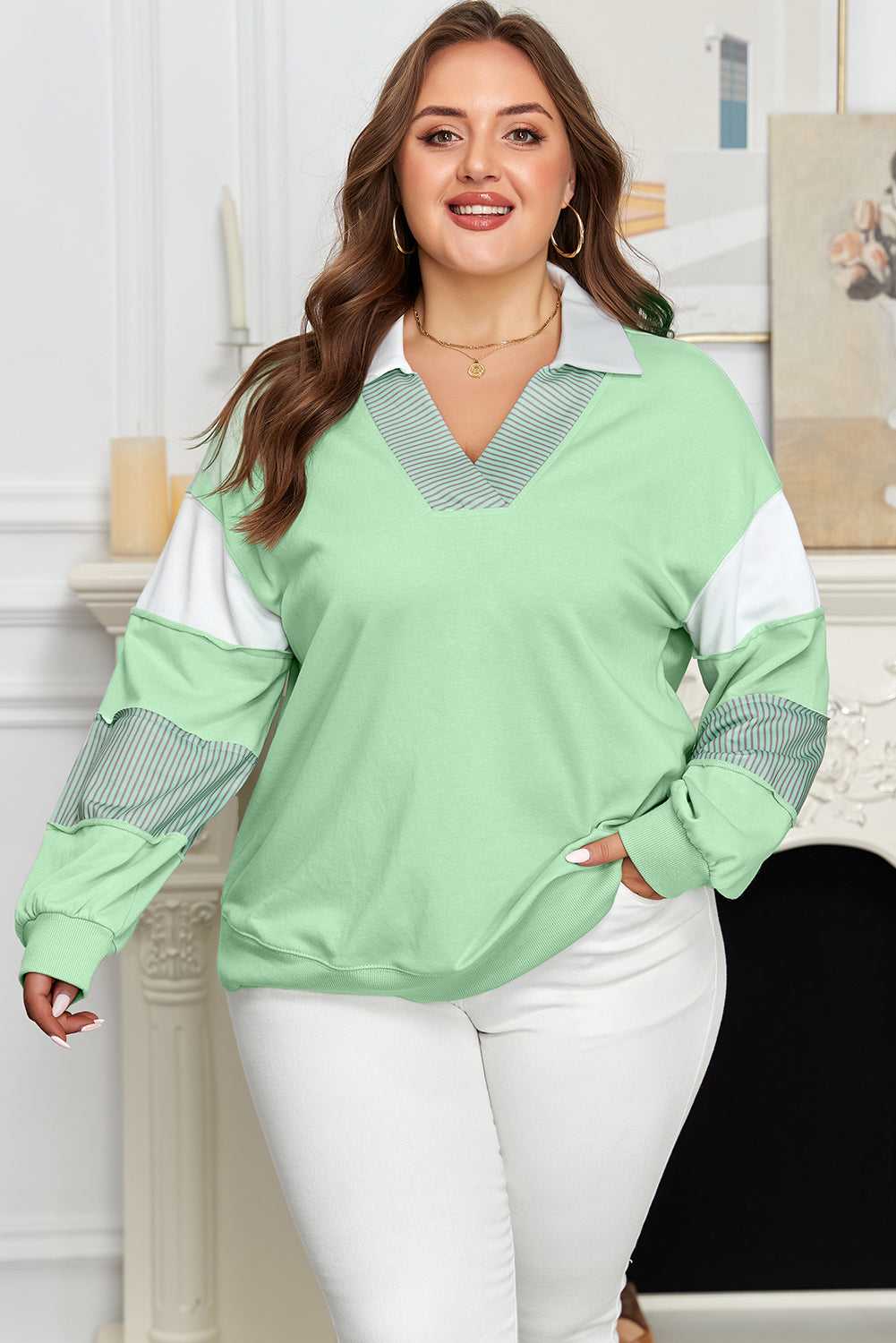 Plus size model wearing Curve Jade Stripe V‑Neck Sweatshirt for Women with white pants, showcasing flattering curve fit.