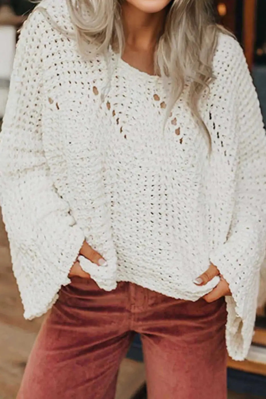 Wide sleeve hollow knit jumper in white with open-knit texture, styled casually with rust corduroy pants for a cozy fall look.