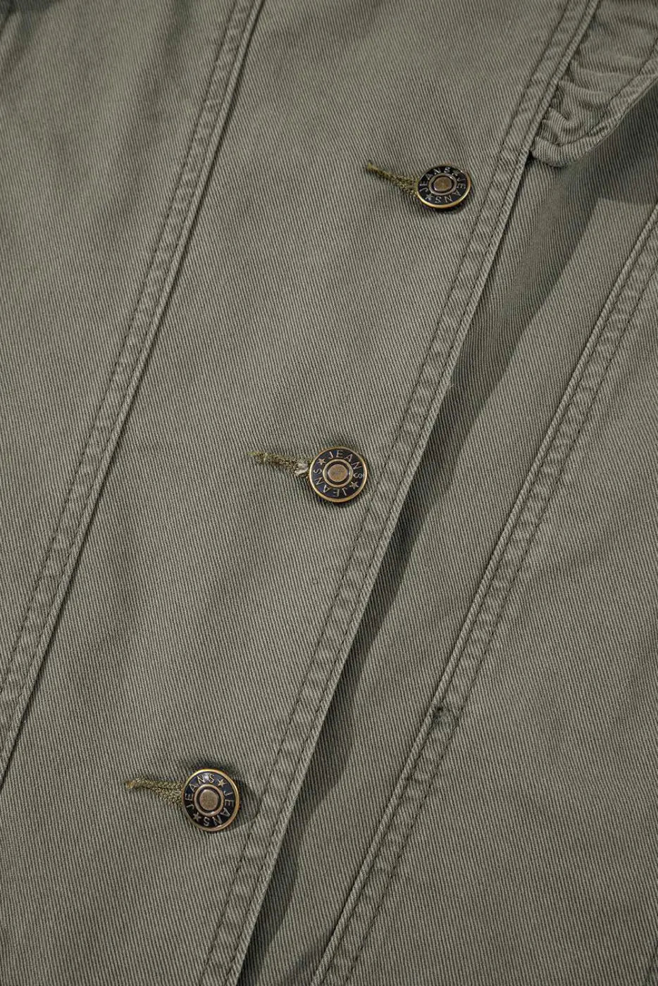 Detailed view of buttons on Green Bay Ruffled Denim Vest - Women's Fashion Trends with metallic accents and reinforced seams.