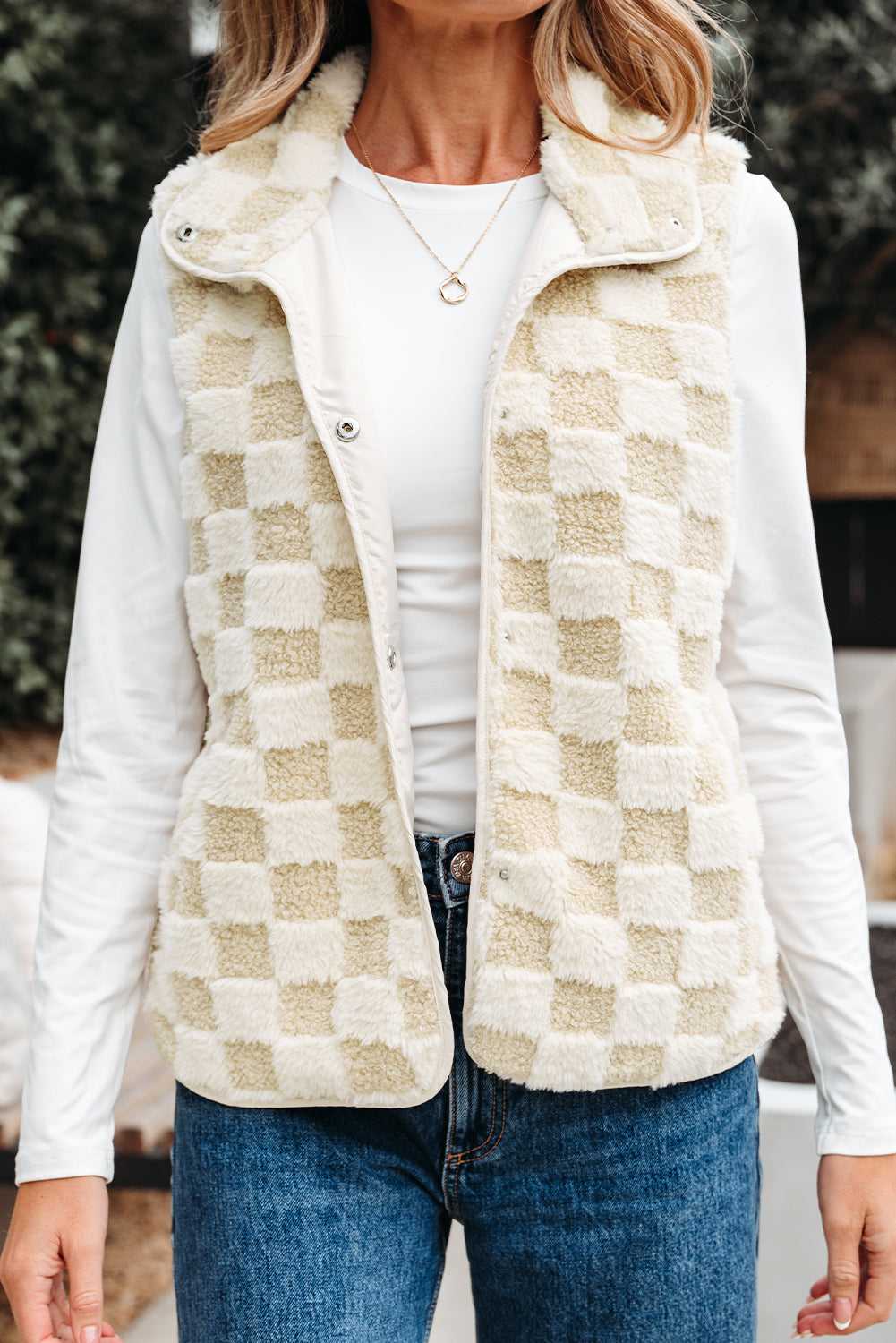 Person wearing a Sherpa Fleece Vest over a white shirt and blue jeans.