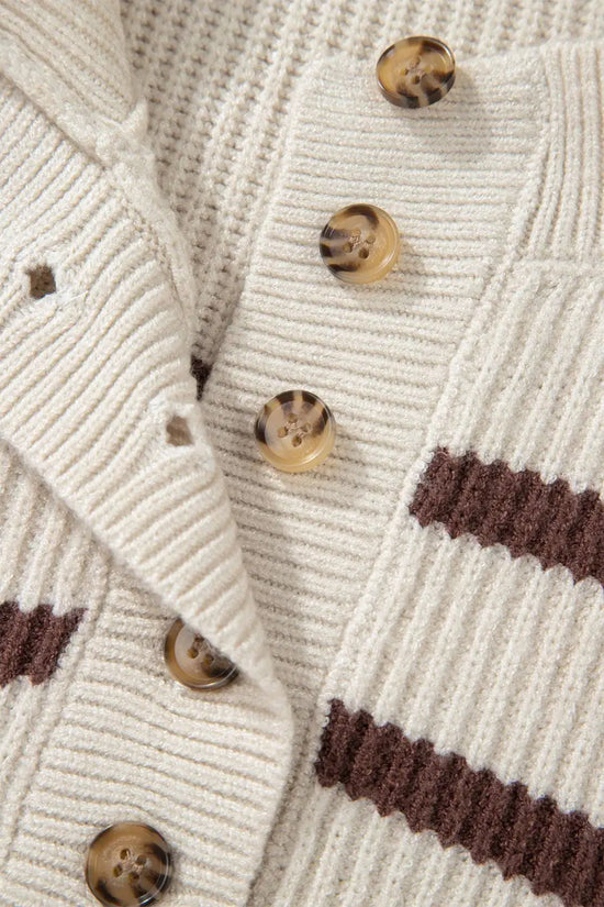 Detail of button placket and ribbed knit texture on casual slouchy striped Henley jumper in cream and brown.