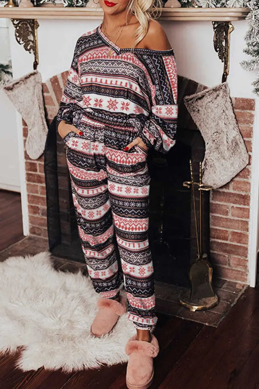 Women's Christmas Comfort Lounge Set in Black by FashionFitz featuring a festive retro pattern, worn in a cozy holiday living room setting.