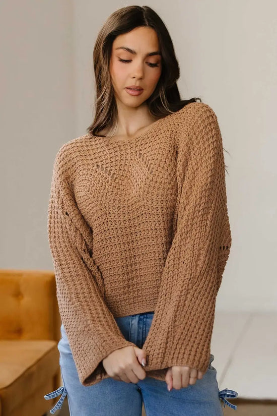 Front close-up of brown wide sleeve hollow knit jumper with flared sleeves, styled for a cozy and casual autumn outfit.