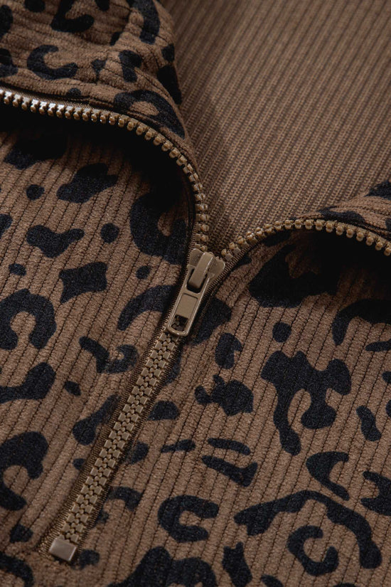 Detail view of zipper and fabric texture on women's brown leopard print corduroy half-zip jumper. Durable metal zip with ribbed knit.