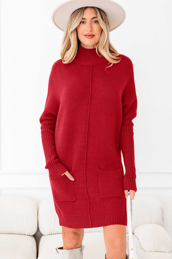 Red high neck knit jumper dress with long sleeves and front pockets, styled for winter fashion. Cozy women’s winter dress in solid red color.