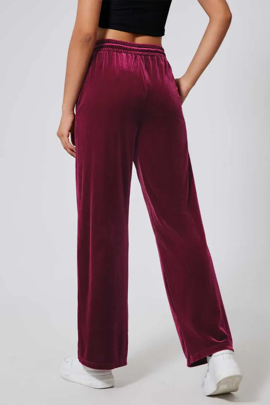Back view of soft burgundy velvet yoga pants featuring relaxed wide-leg fit and elastic waistband, ideal for lounging or daily wear.
