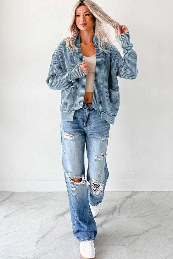 Full-body view of woman in blue stonewash patchwork knit open cardigan with distressed jeans and sneakers, styled for a laid-back fall outfit.