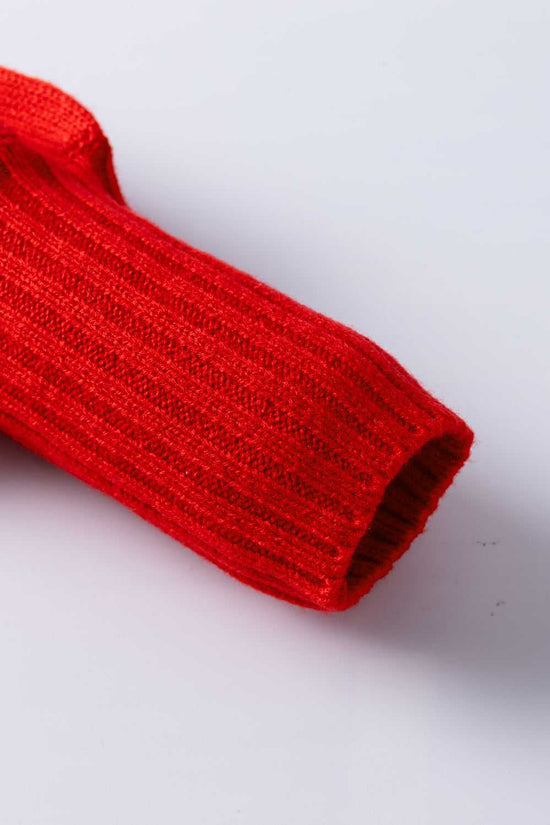 Close-up of ribbed sleeve cuff on red high neck Christmas sweater, showcasing fine acrylic knit texture for winter comfort.