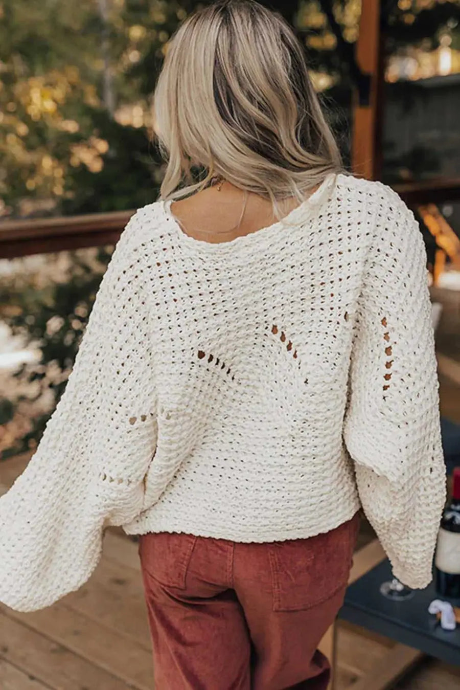Back view of white wide sleeve hollow knit jumper showing relaxed fit and breathable open-knit pattern, ideal for autumn layering.