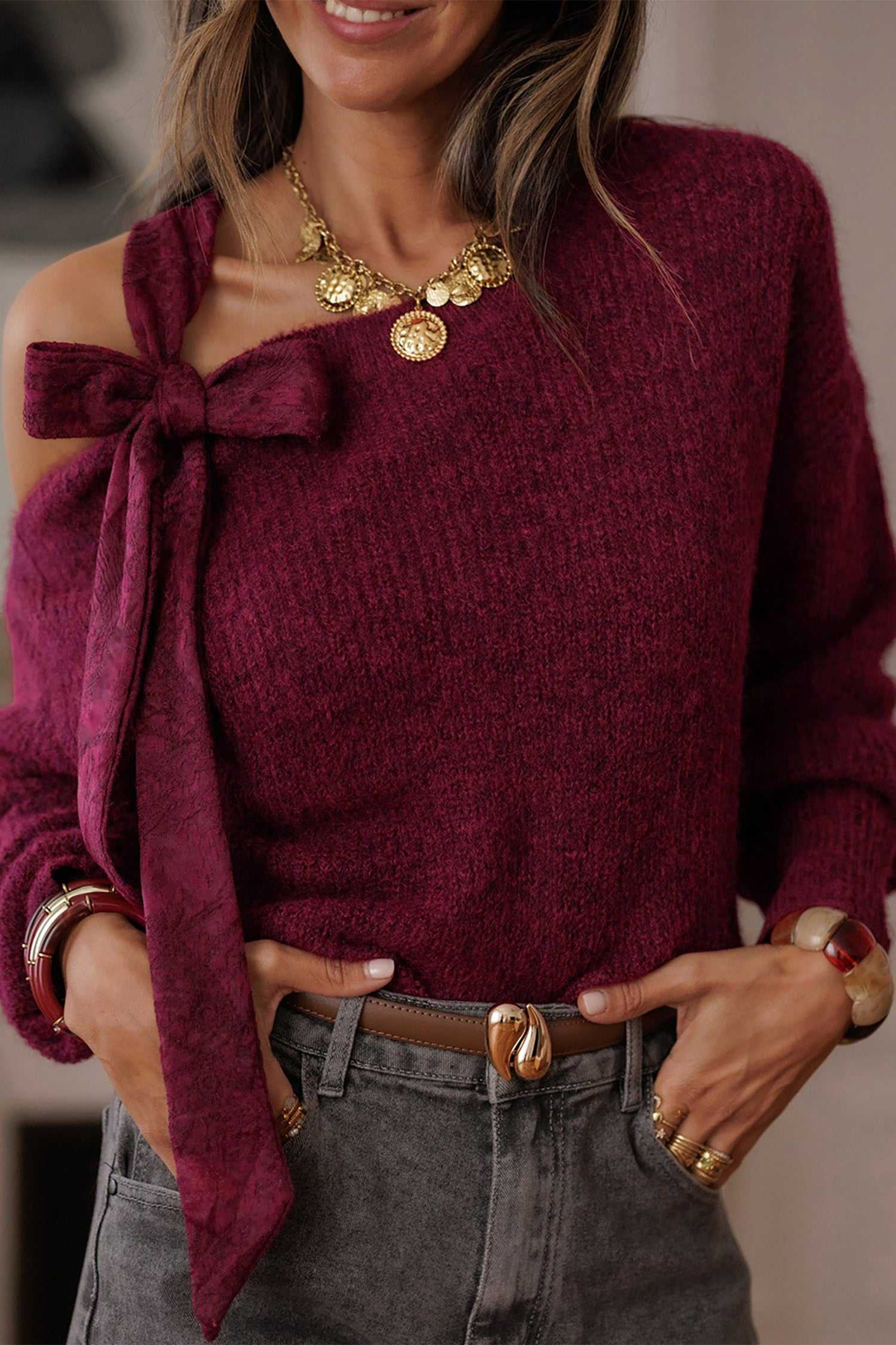 Elegant burgundy off-shoulder sweater with lace bow detail and cozy knit texture. Stylish fall jumper for women, perfect for evening wear.