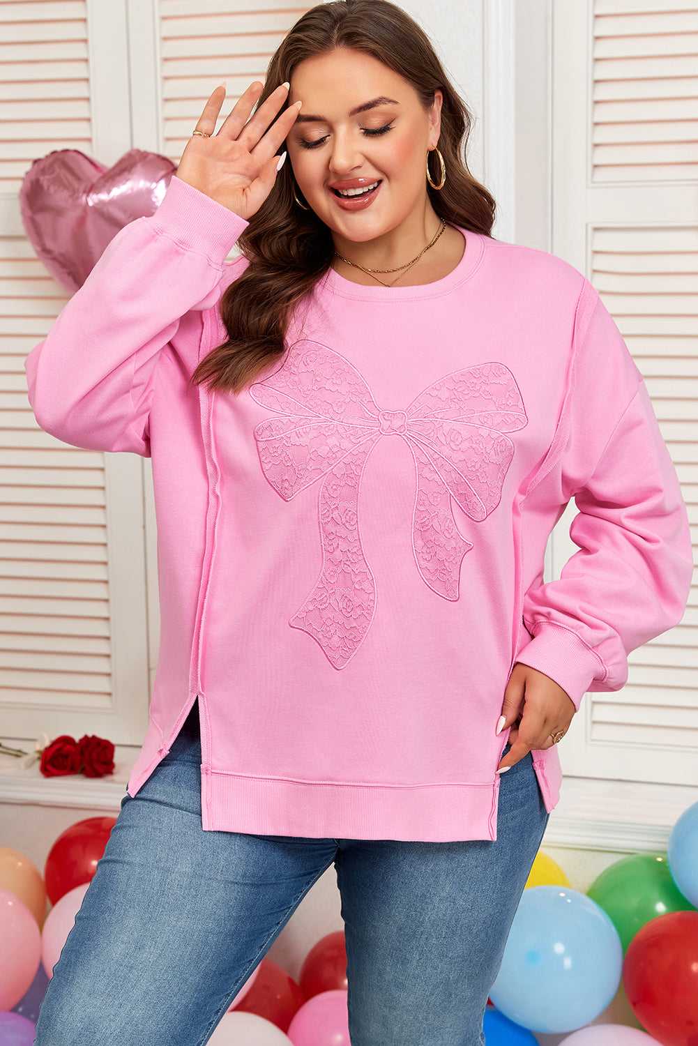Front view of Pink Bow Plus Size Sweatshirt featuring a large lace bow and side slits. A fashionable pullover for curvy women.