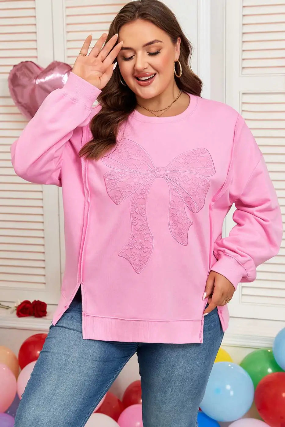 Front view of Pink Bow Plus Size Sweatshirt featuring a large lace bow and side slits. A fashionable pullover for curvy women.