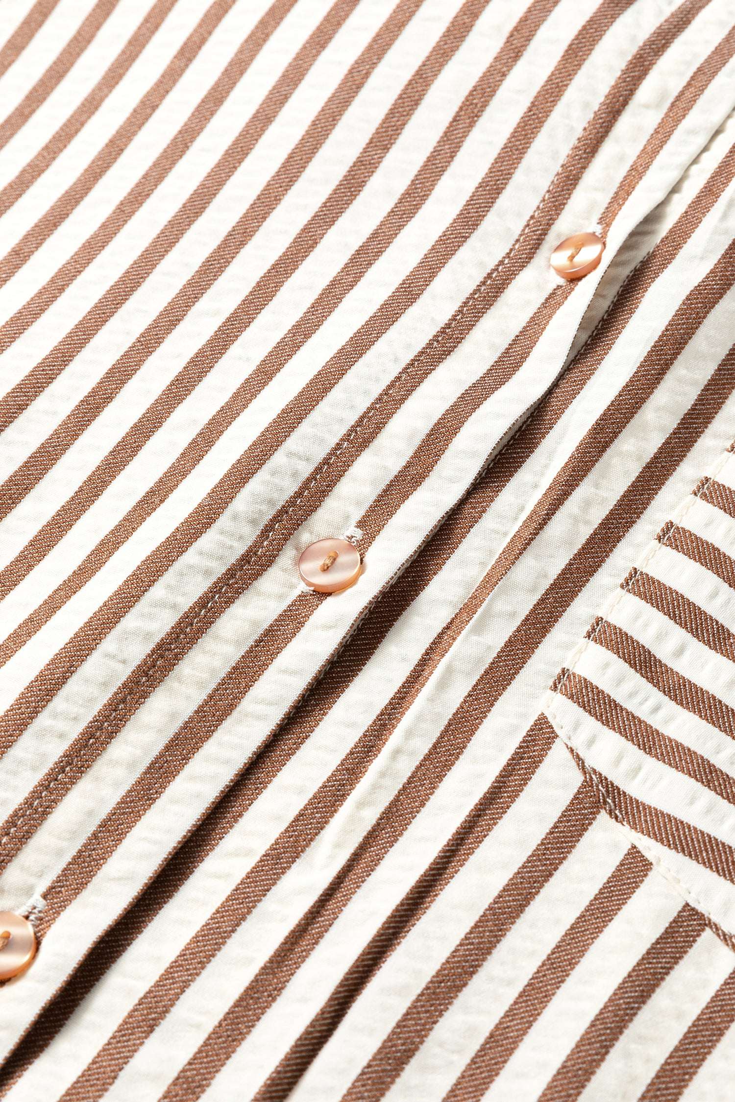 Close-up of brown striped midi shirt dress button placket, highlighting the vertical stripe pattern and stitching detail.