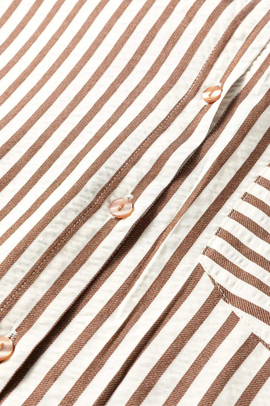 Close-up of brown striped midi shirt dress button placket, highlighting the vertical stripe pattern and stitching detail.