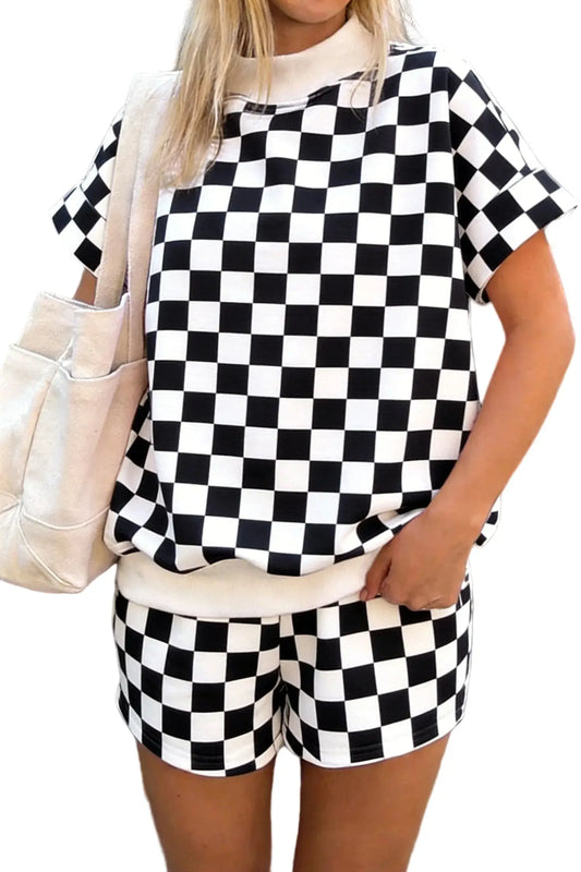 Person wearing a black and white checkered outfit with a beige bag.