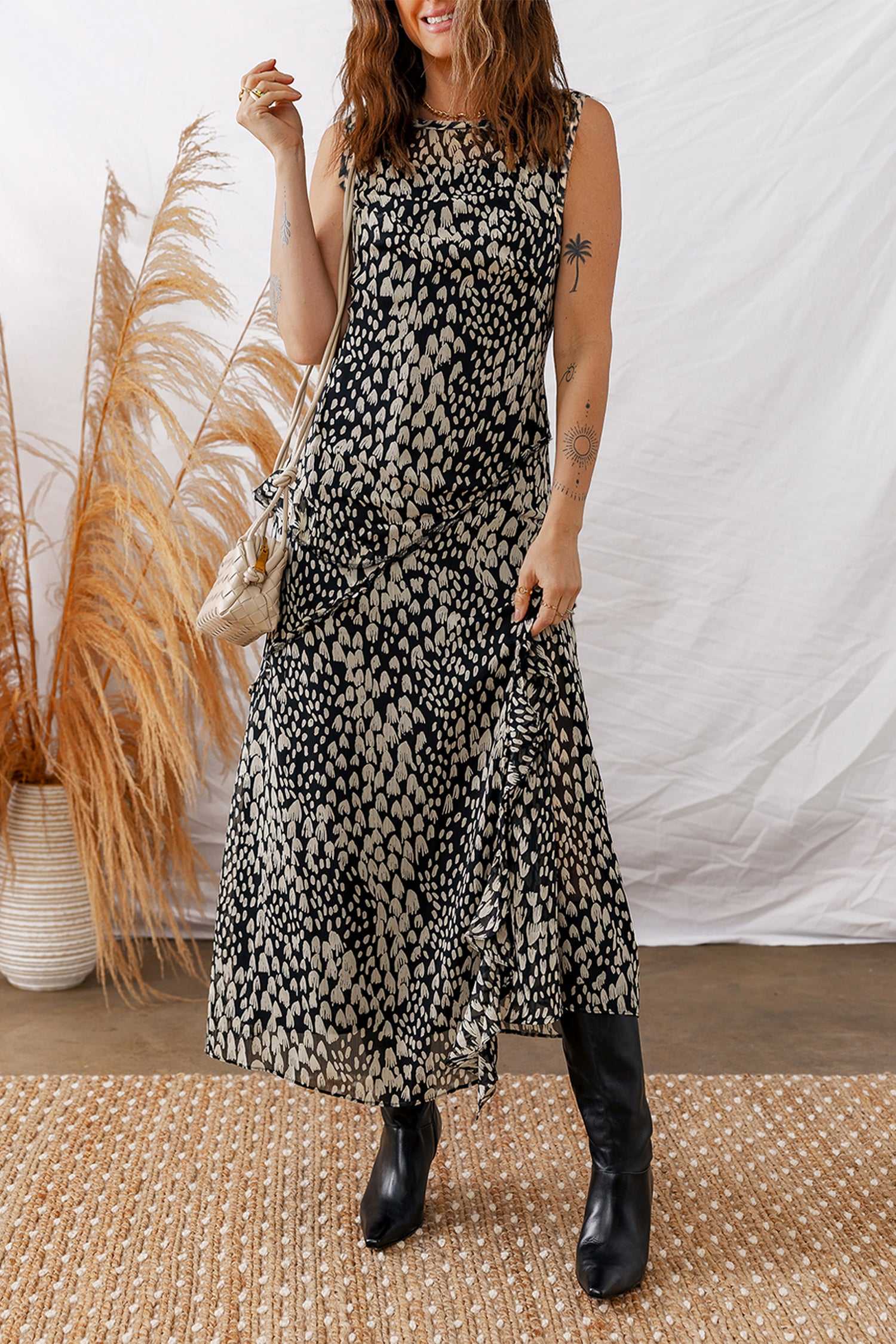 Black Floral Sleeveless Maxi Dress styled with boots and a shoulder bag, perfect for summer garden parties or casual outings.