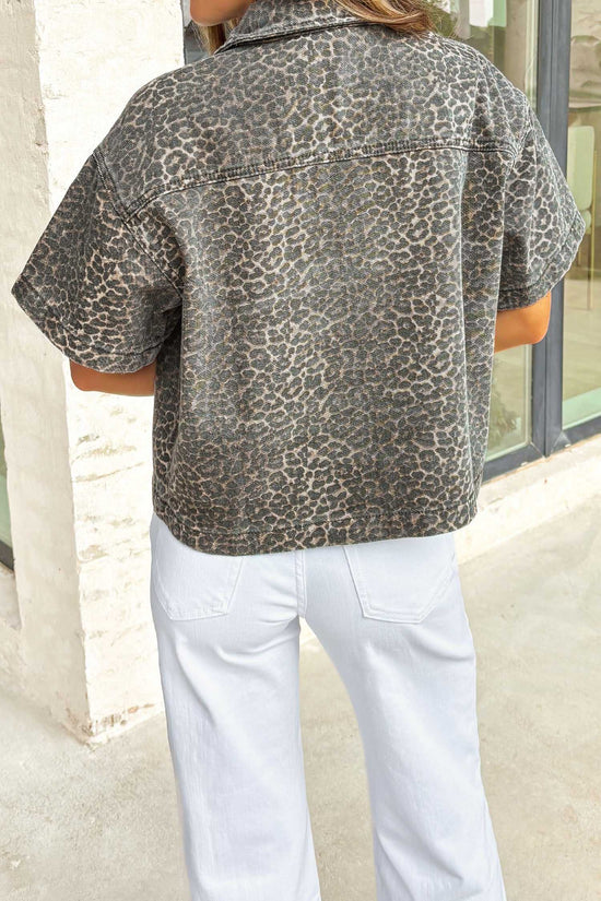 Back view of women's gray leopard short sleeve denim shirt featuring all-over leopard print and cropped western style.