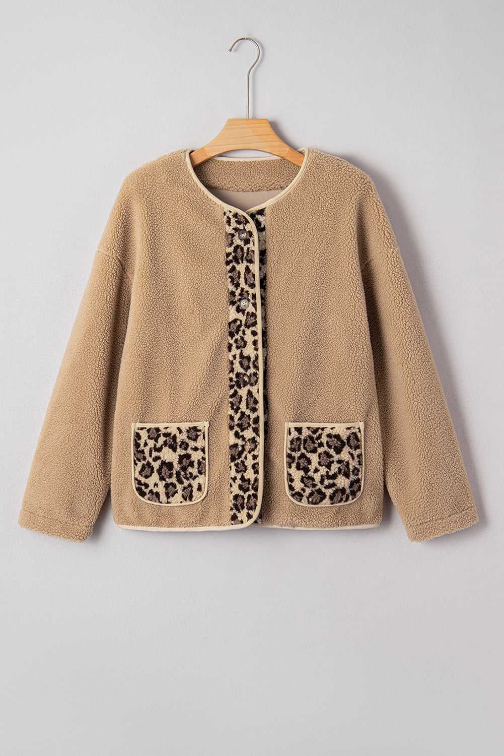Flat lay of women’s plush leopard print jacket on hanger, showcasing fleece texture, front buttons, and animal print panels.