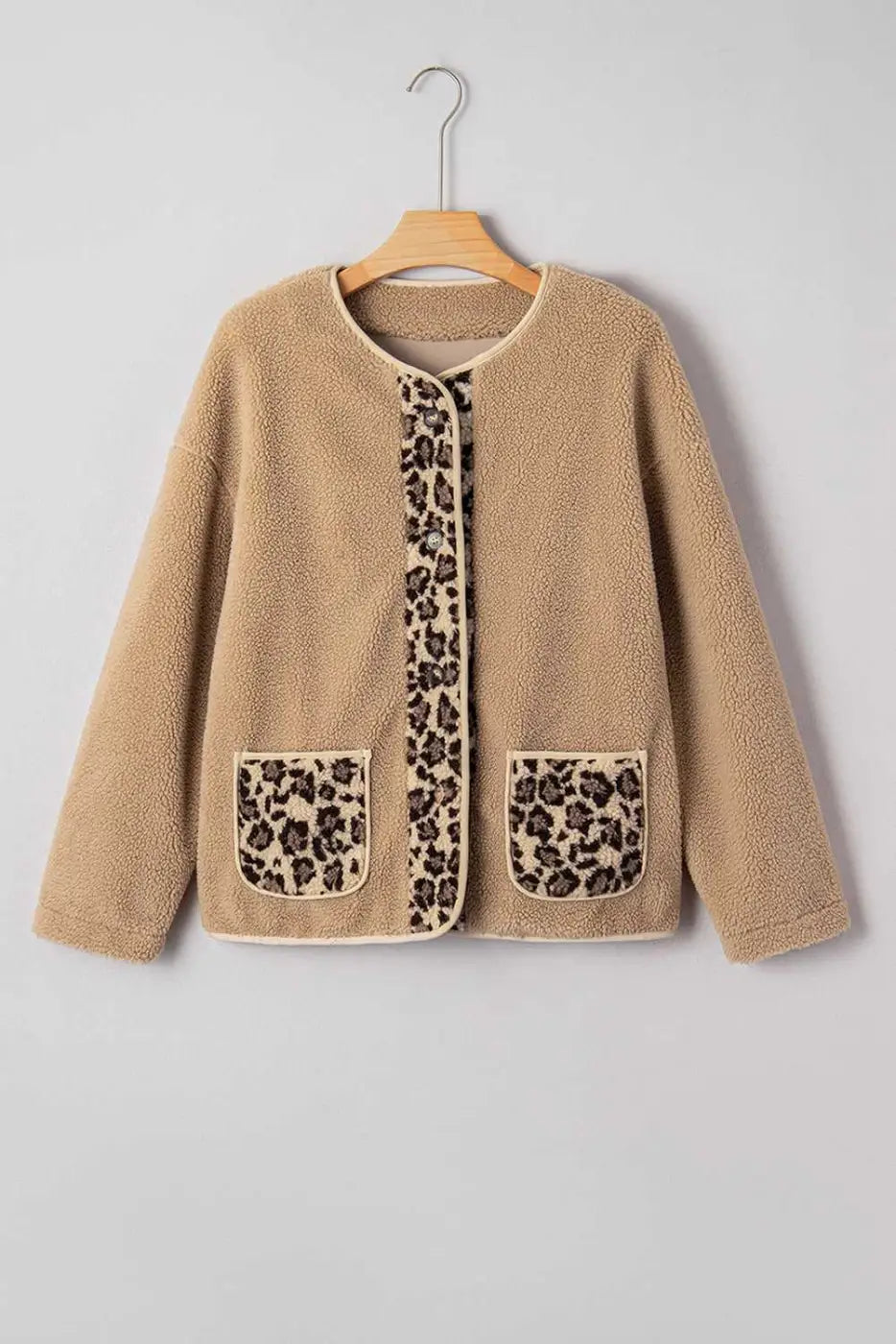Flat lay of women’s plush leopard print jacket on hanger, showcasing fleece texture, front buttons, and animal print panels.