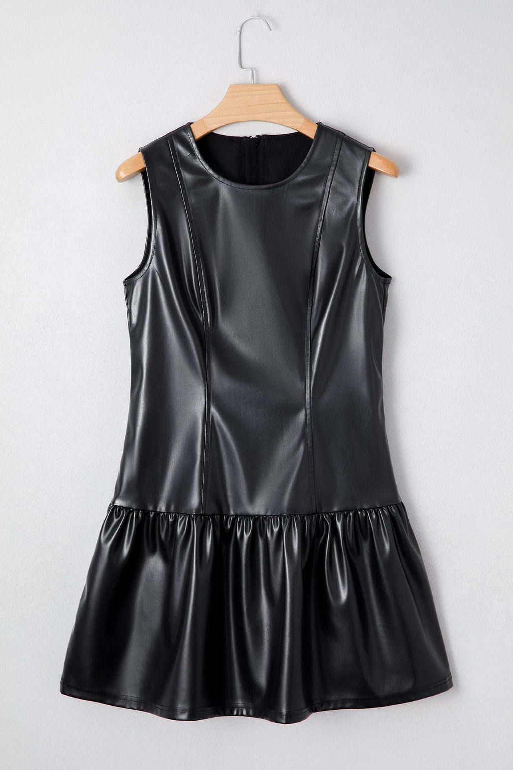 Ladies Black Faux Leather Mini Dress | FashionFitz displayed on hanger showing structured bodice and ruffled mini skirt design.