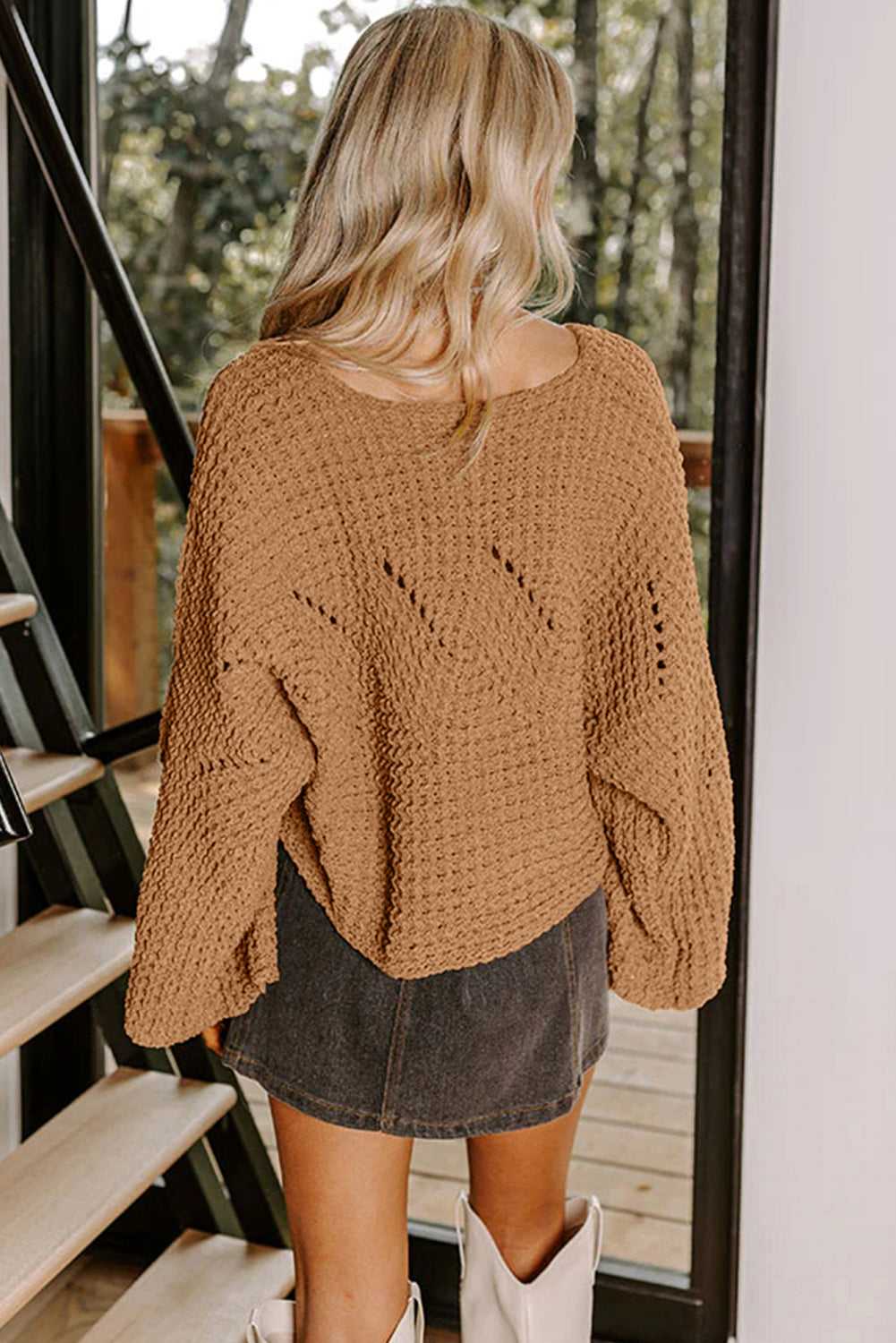 Back view of brown wide sleeve hollow knit jumper with open-knit detailing, styled with a mini skirt for fall fashion.