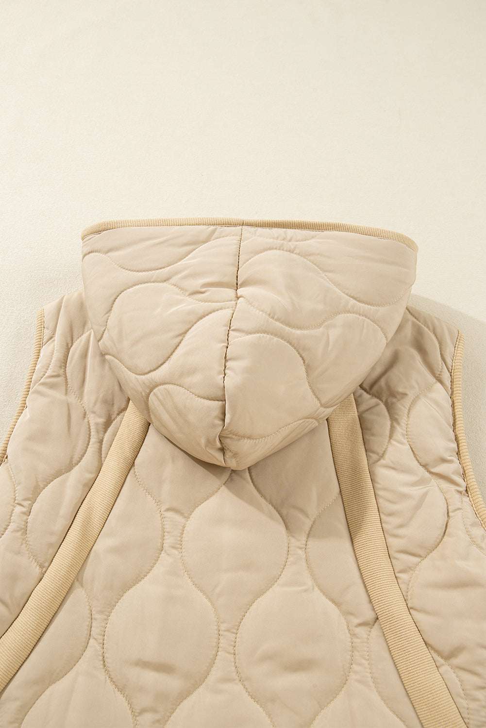 Back detail of khaki Quilted Fleece‑Lined Winter Gilet highlighting hood, quilted texture, and ribbed trim accents.