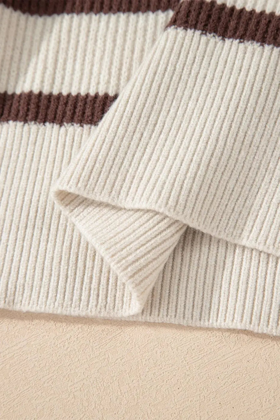 Close-up of ribbed knit hem on casual slouchy striped Henley jumper, highlighting soft lightweight fabric texture.