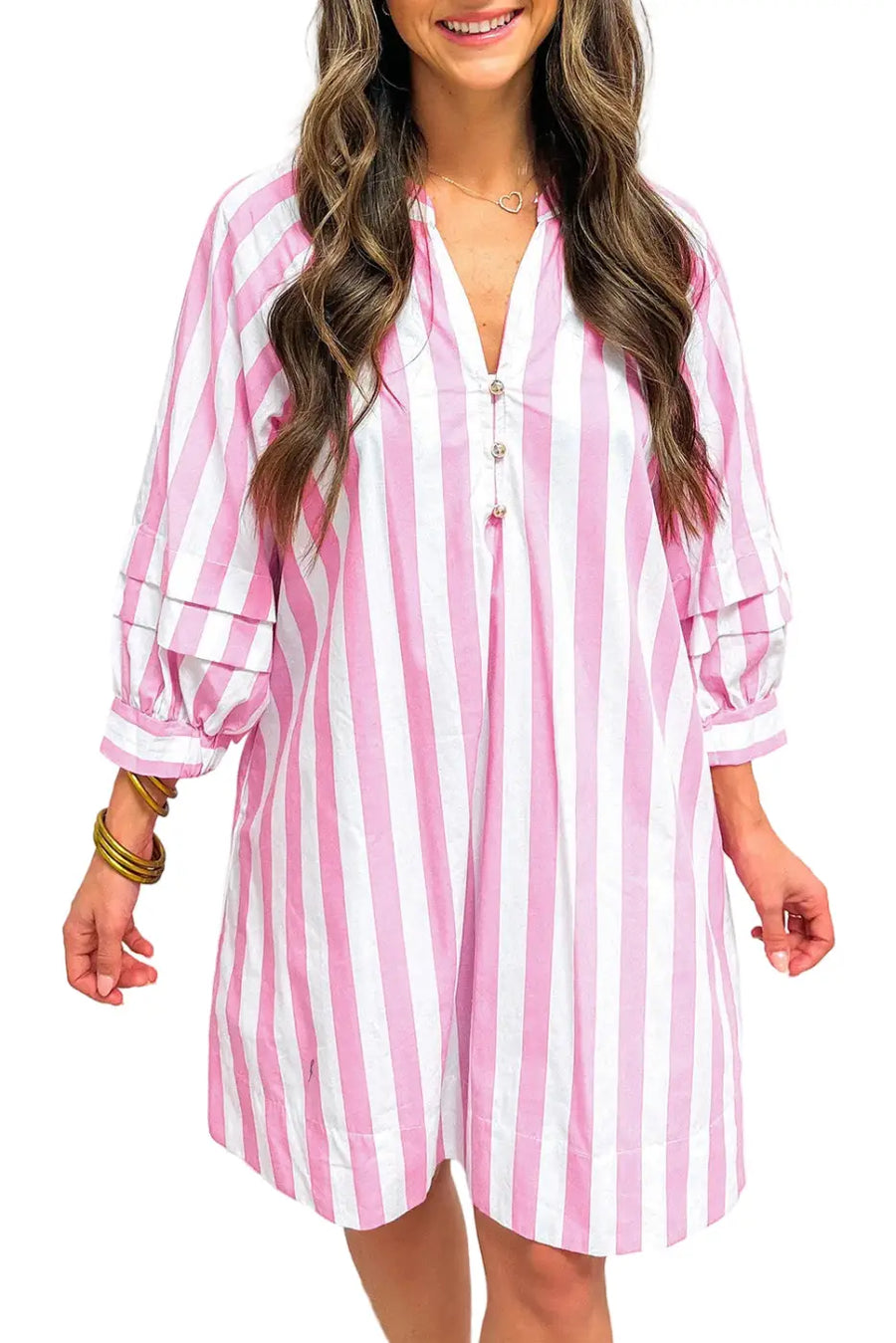 Woman wearing a pink and white striped dress against a plain background