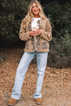 Full body view of woman wearing plush leopard print jacket with fleece texture, styled for autumn with jeans and cozy footwear.