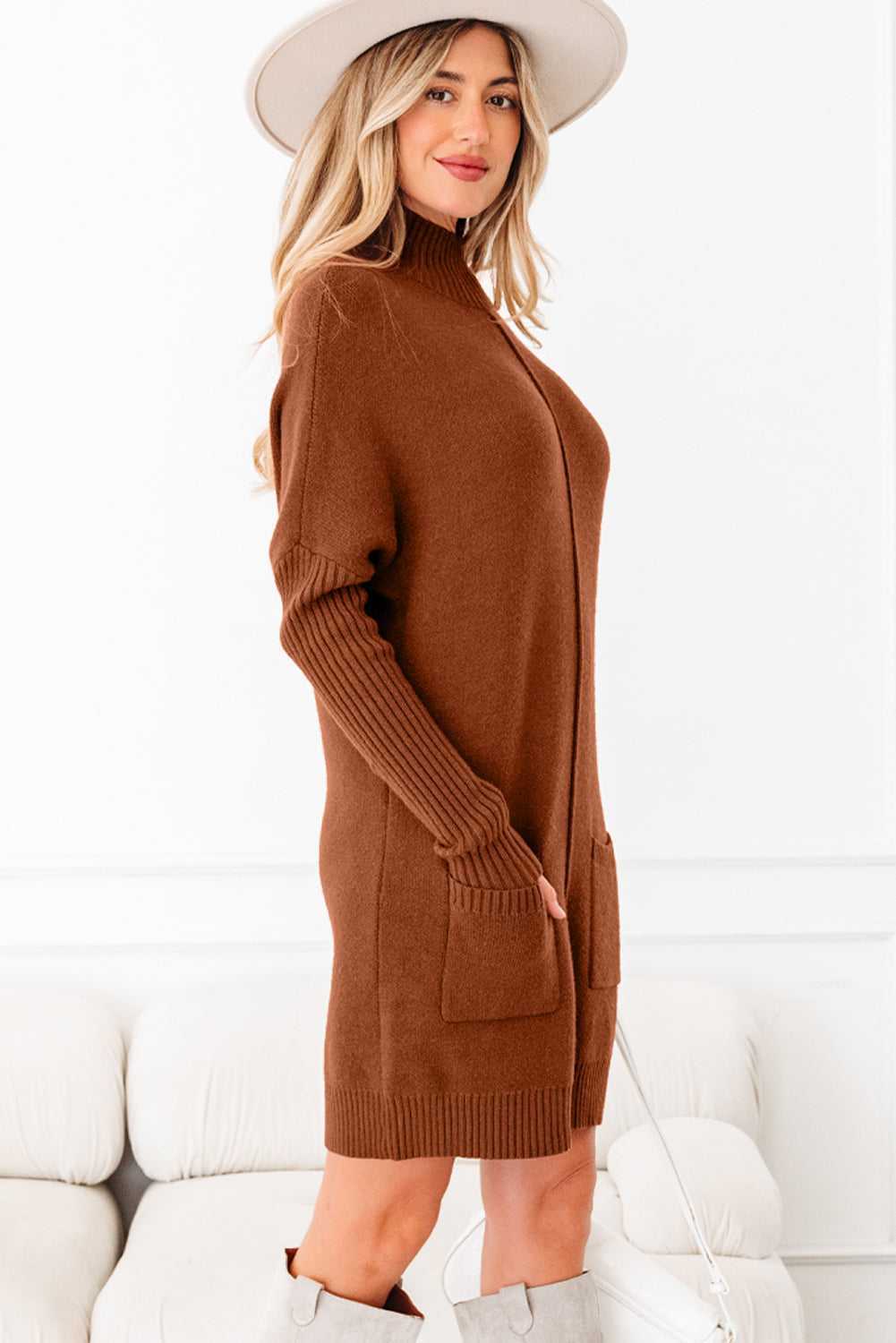 Side view of brown high neck knit jumper dress with long ribbed sleeves and patch pockets. Soft knit sweater dress for winter fashion.
